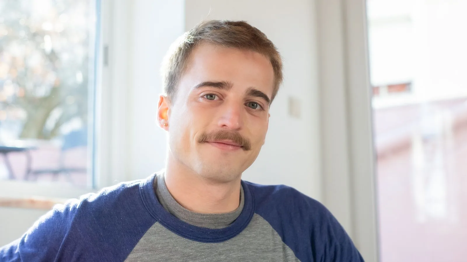 Portrait de Romain, 34 ans, développeur à Lille, souriant légèrement
